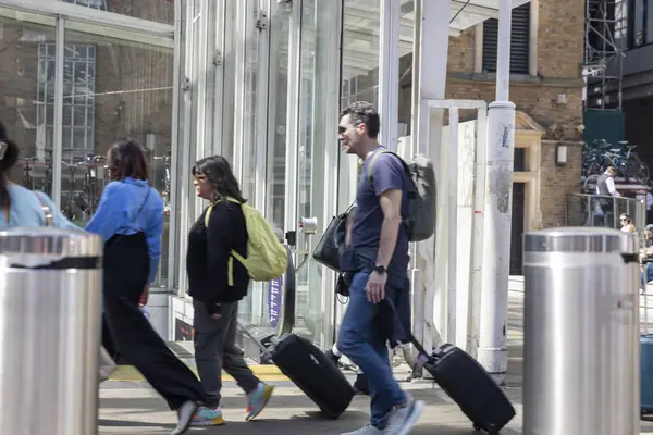 Londra, İngiltere, 7 Mayıs 2025, People 's Walking with Bavulside a Modern Building. Bulanık kavram