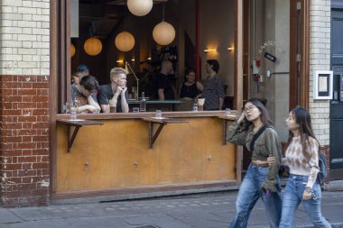 Londra, İngiltere, 7 Mayıs 2025, Müşterilerle Rambutan Restoranı Sokak Manzarası. Barın penceresinde düşünceli bir adam..