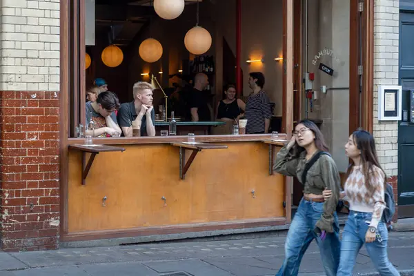 Londra, İngiltere, 7 Mayıs 2025, Müşterilerle Rambutan Restoranı Sokak Manzarası. Barın penceresinde düşünceli bir adam..