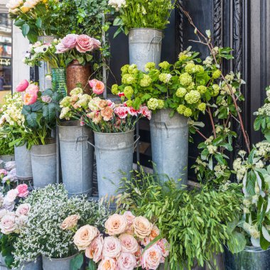 Bir mağazanın dışındaki kovalarda çiçeklerin yakın plan görüntüsü.