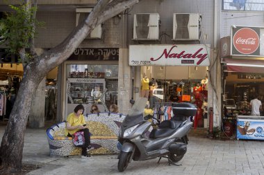 Petah Tikva, İsrail, 12 Haziran 2025 Petah Tikva 'da bir bankta dinlenen bir kadın..