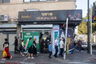 Petah Tikva, İsrail, 12 Haziran 2025, Yoğun bir cadde boyunca çeşitli dükkanları olan farklı bir grup insan.