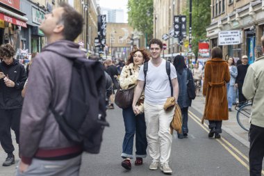 Londra, İngiltere, 15 Mayıs 2025, Genç Çift Brick Lane Market 'te El ele yürüyor