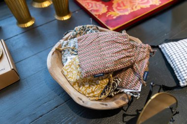 Londra, İngiltere, 15 Mayıs 2025, Özgürlük Dükkanı. Ahşap bir kase, muhtemelen küçük eşyalar ya da hediyeler için bir perakende vitrininde çeşitli desenli kumaş iplik torbaları bulundurur..