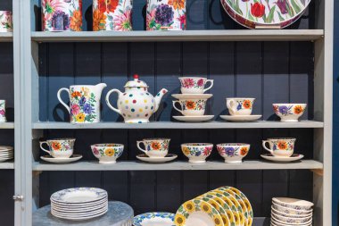 Renkli çömlek sergisi raflarda.