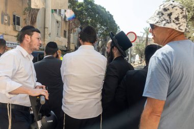 Haifa, Israel, 22 June 2025  A group of men, including Ultra-Orthodox Jews, watch as rubble is cleared away. An Iranian missile hits a fountain and a building in the Adar district. The Israeli-Iranian War.