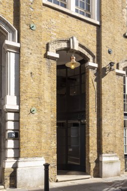 Londra, İngiltere, 7 Mayıs 2025, Asılı Lambalı Bir Tuğla Binanın Kemerli Girişi.