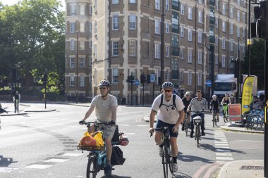 Londra, İngiltere, 7 Mayıs 2025, İki Erkek Bisikletçi Bir Şehir Sokağında Süzülüyor.