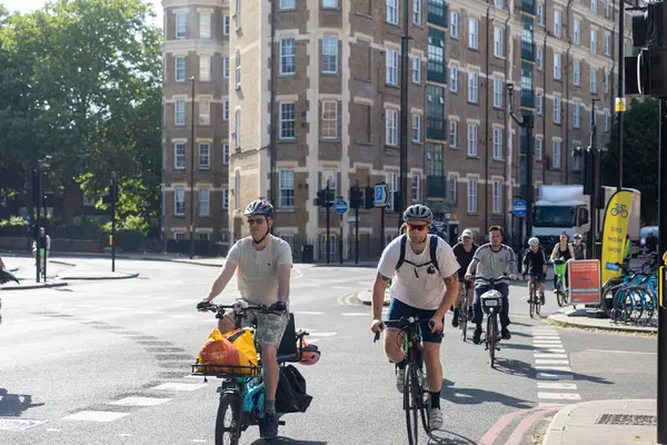 Londra, İngiltere, 7 Mayıs 2025, İki Erkek Bisikletçi Bir Şehir Sokağında Süzülüyor.
