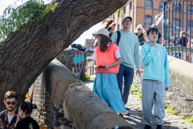 Londra, İngiltere, 11 Mayıs 2025, Kalabalık Şehir Sahnesine Bakan Büyük Bir Ağacın yanında İnsanlar Bir Taş Yol Üzerinde Yürüyor