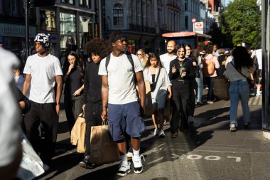 Londra, İngiltere, 9 Mayıs 2025 Sunny City Caddesi 'nde Yürüyen İnsanlar. Etnik çeşitliliğe sahip çok sayıda genç ve yetişkin erkek ve kadın bulunmaktadır.