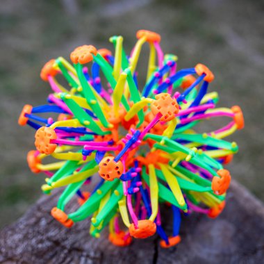 Hoberman küresi olarak bilinen renkli genişleyen bir top oyuncağının yakın plan görüntüsü, açık havada bir ağaca yerleştirilmiş..