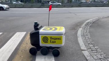 Moskova, Rusya, 2 Ağustos 2025. Altı tekerlekli küçük bir Yandex. Teslimat robotu kuryesi, Aeroport metro istasyonu yakınlarındaki bir yaya geçidinden karşıya geçiyor..
