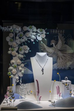 Londra, İngiltere, 2 Aralık 2024 Lüks Mücevher Mağazası Chopard vitrin vitrininde beyaz göğüslü, dekoratif unsurlarla çevrili ve büyük, karmaşık bir kağıt tavus kuşu. Chopard, İsviçre Lüks Saatleri ve Mücevherleri,