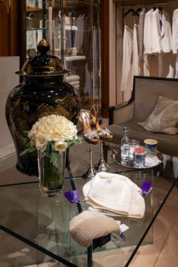 Londra, İngiltere, 24 Kasım 2024. Bir Ralph Lauren mağazasının içinde cam sehpanın sergilendiği siyah ve altın seramik bir vazo ve beyaz güllerden oluşan açık bir vazo.