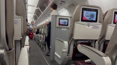 Tiflis, Gürcistan, 13 Temmuz 2025, Boeing 737-300 Gürcistan Havayolları 'nın içi. Yolcular koridorda yürürler. Bir hostes onları karşılıyor..