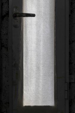 Güneş ışığı şeffaf bir kapıdan düşer.