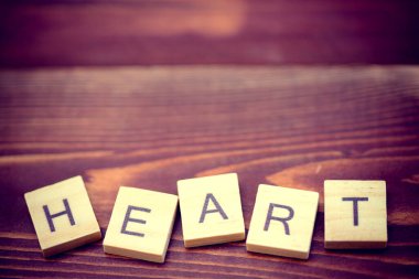 Eski ahşap arka planda alfabe kalbi