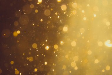 Siyah arkaplanda koyu soyut altın bokeh parıltısı