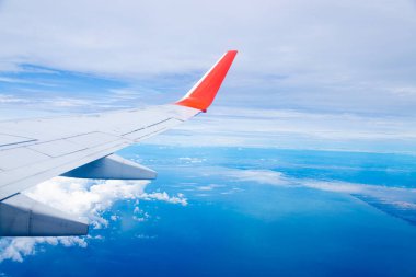 Mavi gökyüzünde doğal arka planda bir uçak kanadı.