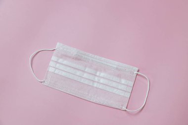 Face mask to help prevent infection from Covid-19 on pink background