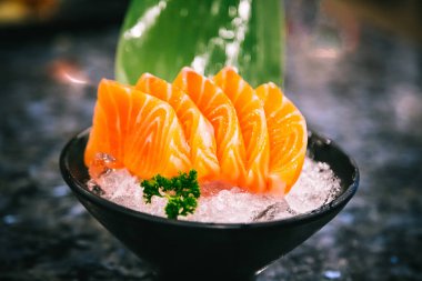 Salmon sashimi is often the first course in a formal Japanese meal over marble black background
