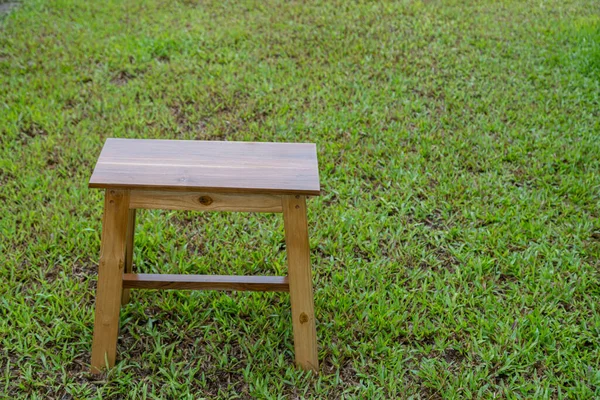 High chair made of wood with grass background