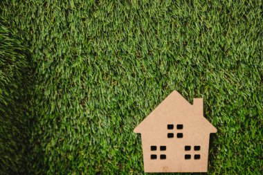 Yapay çimlerin üzerinde küçük ahşap bir ev.