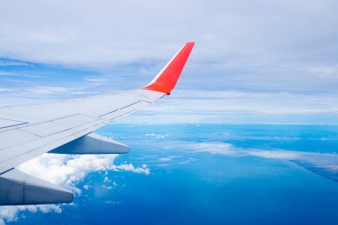 Mavi gökyüzünde doğal arka planda bir uçak kanadı.