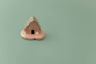 Yumuşak yeşil arka planda küçük bir model ev