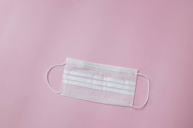 Face mask to help prevent infection from Covid-19 on pink background