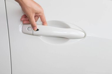 Closeup shot of female hand opening white car's door