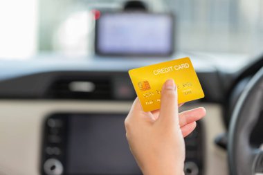 Driver paying with credit card isolated on car background