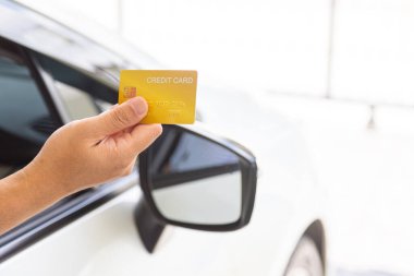 Closed up hand use credit card on car to pay for fuel