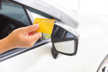 Closed up hand use credit card on car to pay for fuel