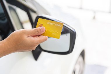 Closed up hand use credit card on car to pay for fuel