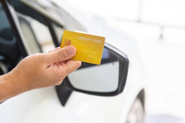 Closed up hand use credit card on car to pay for fuel