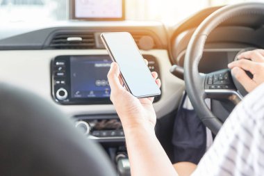 man using a mobile phone while driving a car