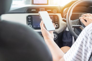 man using a mobile phone while driving a car