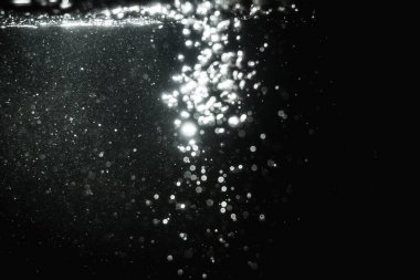 Siyah arkaplanlı kutlama için bulanık beyaz bokeh yıldızlarını kullan