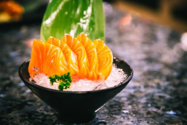 Salmon sashimi is often the first course in a formal Japanese meal over marble black background