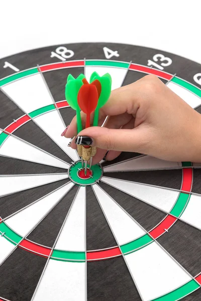 Hands with darts at the target center on a white background