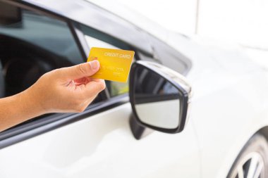 Closed up hand use credit card on car to pay for fuel