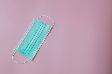 Face mask to help prevent infection from Covid-19 on pink background