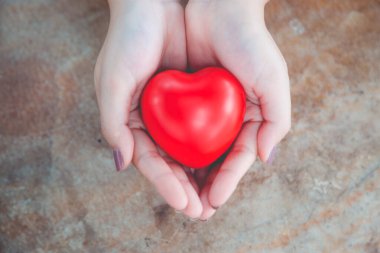 Kadın arka plan için kırmızı kalp kullanım tutun