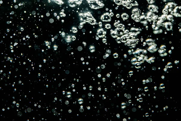 黒を背景に水の中の光からぼっしょり — ストック写真