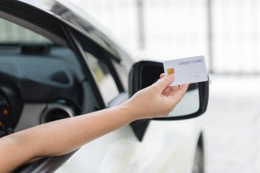 Closed up hand use credit card on car to pay for fuel