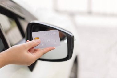 Closed up hand use credit card on car to pay for fuel