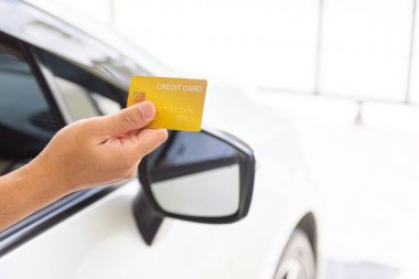 Closed up hand use credit card on car to pay for fuel