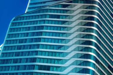 Mavi gökyüzü geçmişi olan lüks modern bina ofisini kapatın.